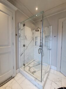 Bespoke frameless glass shower enclosure with hinged door installed in London polished nickel fittings