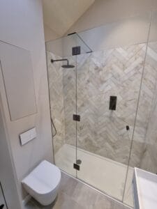 Modern frameless glass shower enclosure with gun metal fittings installed in London