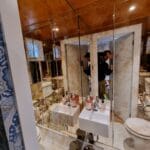 Full height antique mirror wall installation in a narrow toilet