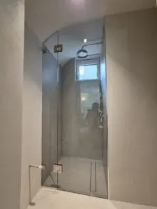 Custom glass shower enclosure designed for a sloping ceiling bathroom