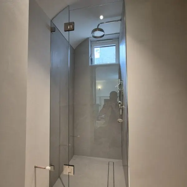 Custom glass shower enclosure designed for a sloping ceiling bathroom