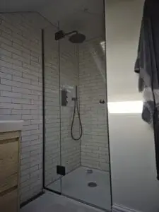 Frameless glass shower enclosure for sloping ceiling loft bathroom in South West London