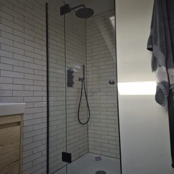 Frameless glass shower enclosure for sloping ceiling loft bathroom in South West London