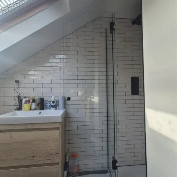 Made-to-measure glass shower enclosure for an angled ceiling bathroom