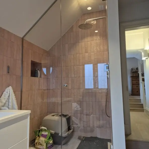 Bespoke shower glass enclosure for sloping ceiling with chrome fittings
