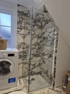 Custom glass shower enclosure for loft conversion bathroom with sloping ceiling