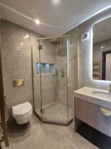 Custom corner glass shower enclosure with hinged door in South West London