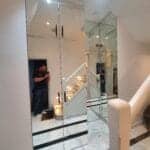 Crystal clear low iron mirror wall installation in a modern hallway