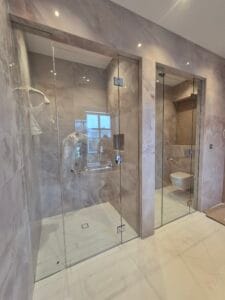 Bespoke frameless glass shower enclosure with hinged door installed in London